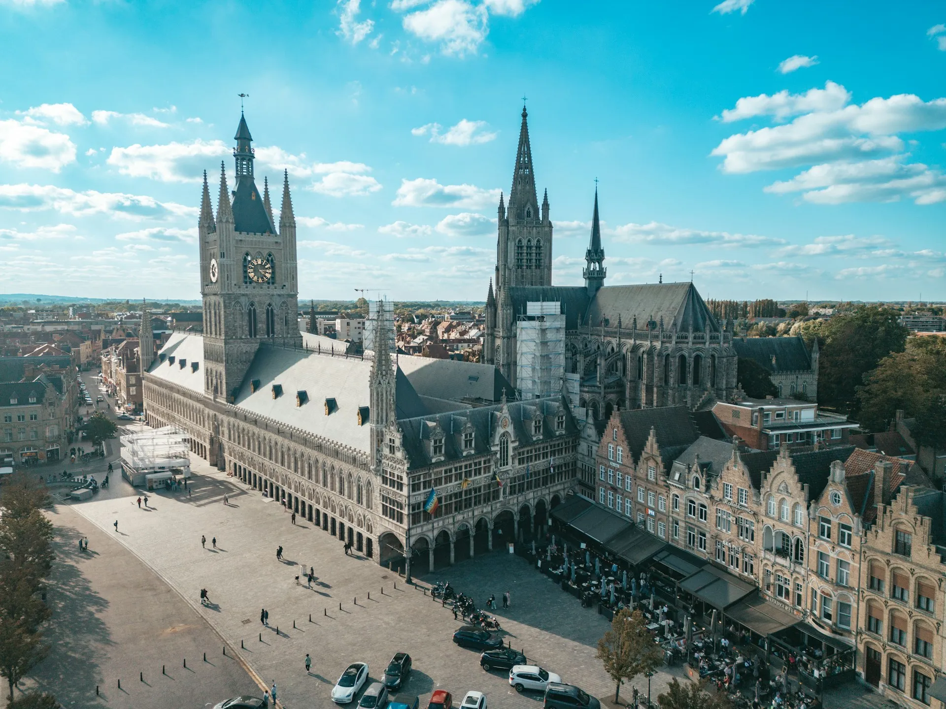 Vue sur la Grand-Place d'Ypres avec les Halles aux draps reconstituées et la Porte de Menin en arrière-plan au crépuscule