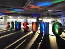 Sunlight streaming through an event venue with Samsung logo signage