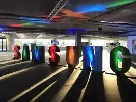 Sunlight streaming through an event venue with Samsung logo signage