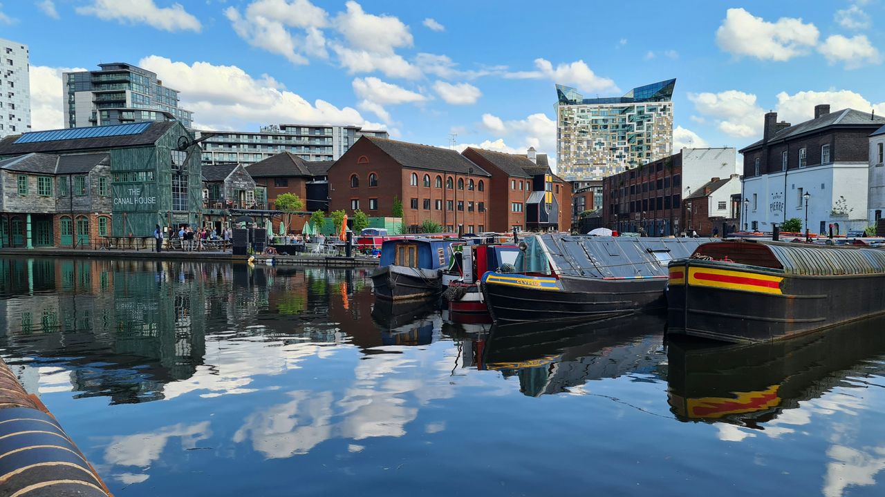 Birmingham canal boats and waterfront buildings on a sunny day